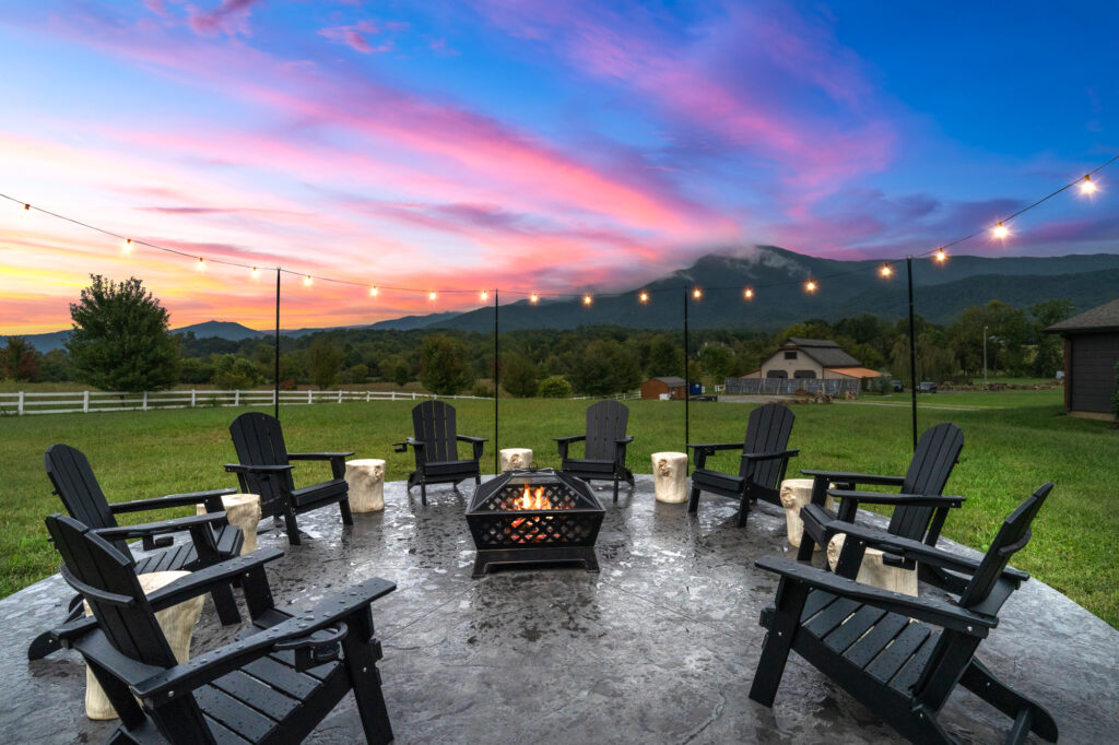 Out door sitting space with camp fire at a luxury STR listing photographed at twilight in Sevierville TN