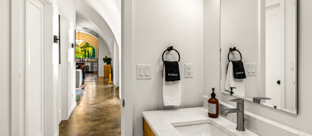 bathroom sink with sneak peak into main living space of a hobbit house photographed in Knoxville TN for a vacation rental listing