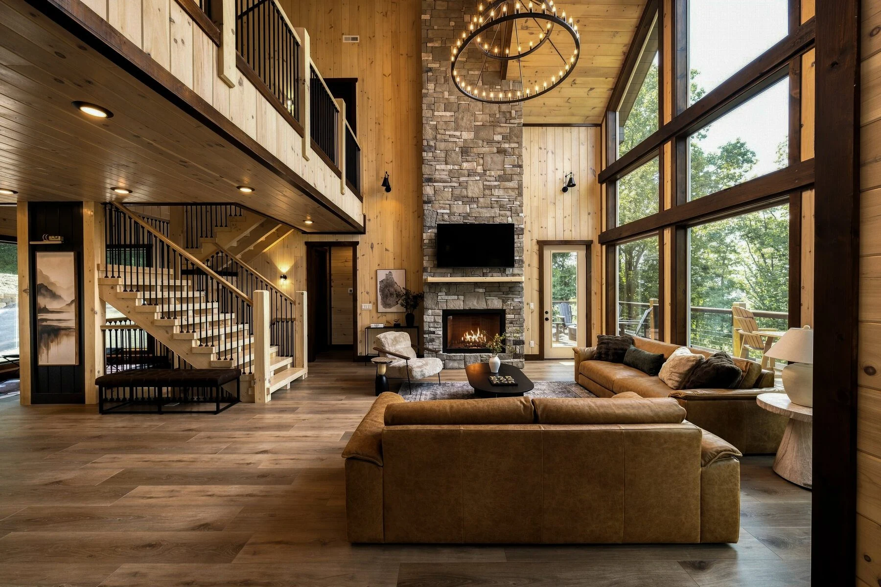 Great room with the stone fireplace and window wall at The Forrest House in Gatlinburg