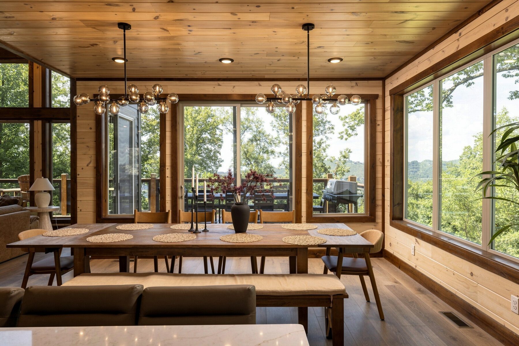 Dining area surrounded by windows and forest views