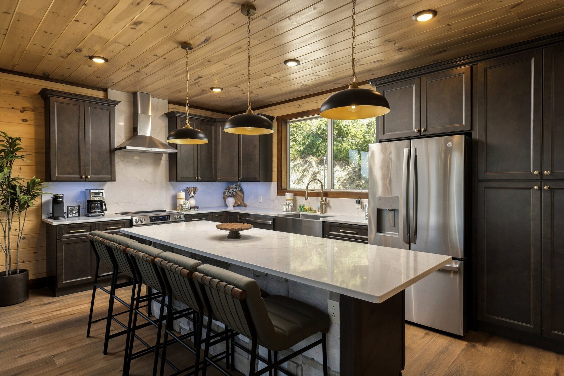 Kitchen with dark cabinetry and a pale waterfall island
