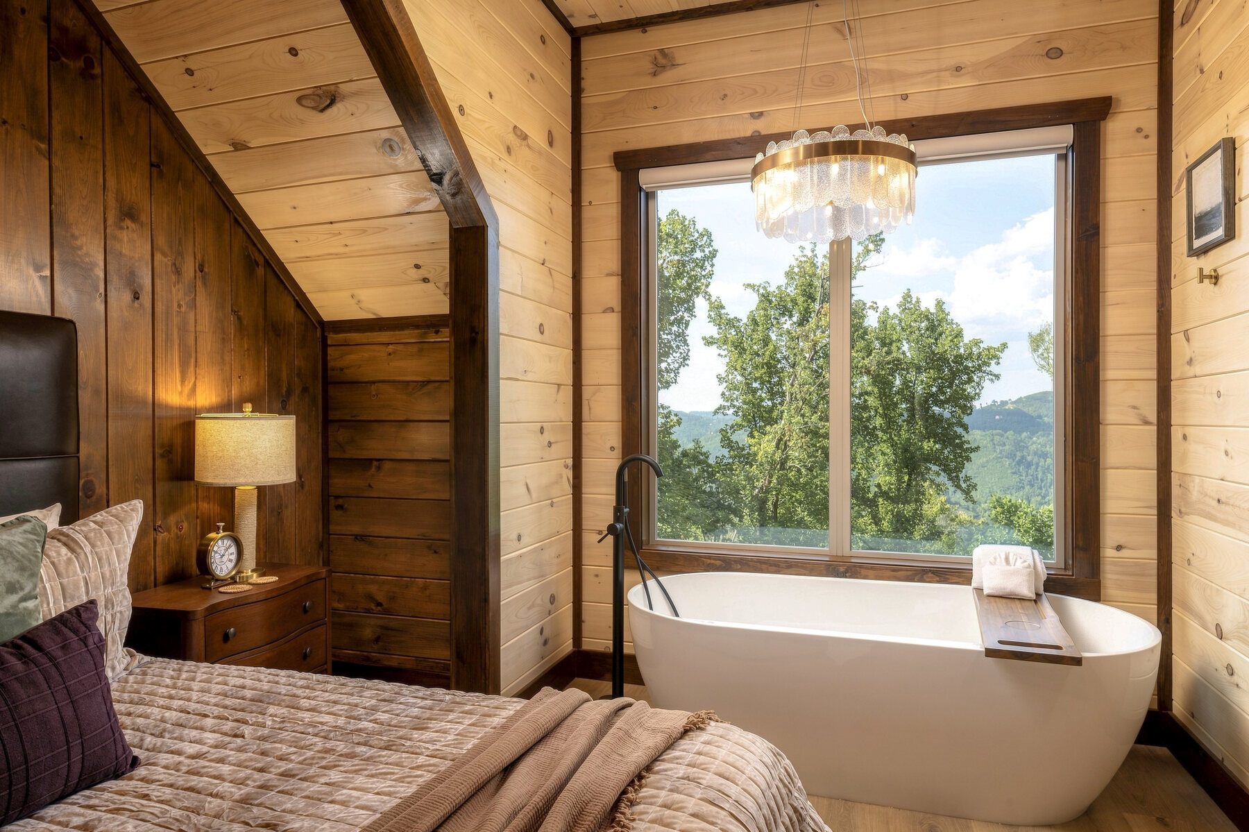 Bedroom opening toward a freestanding tub and window