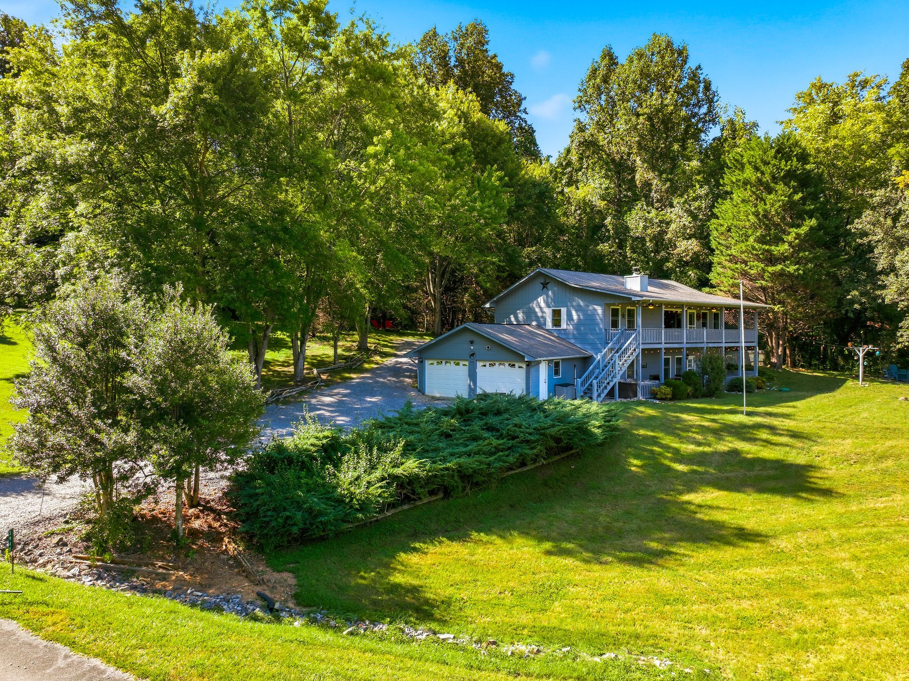 Daytime exterior of FOURtunate View surrounded by lawn and mature trees