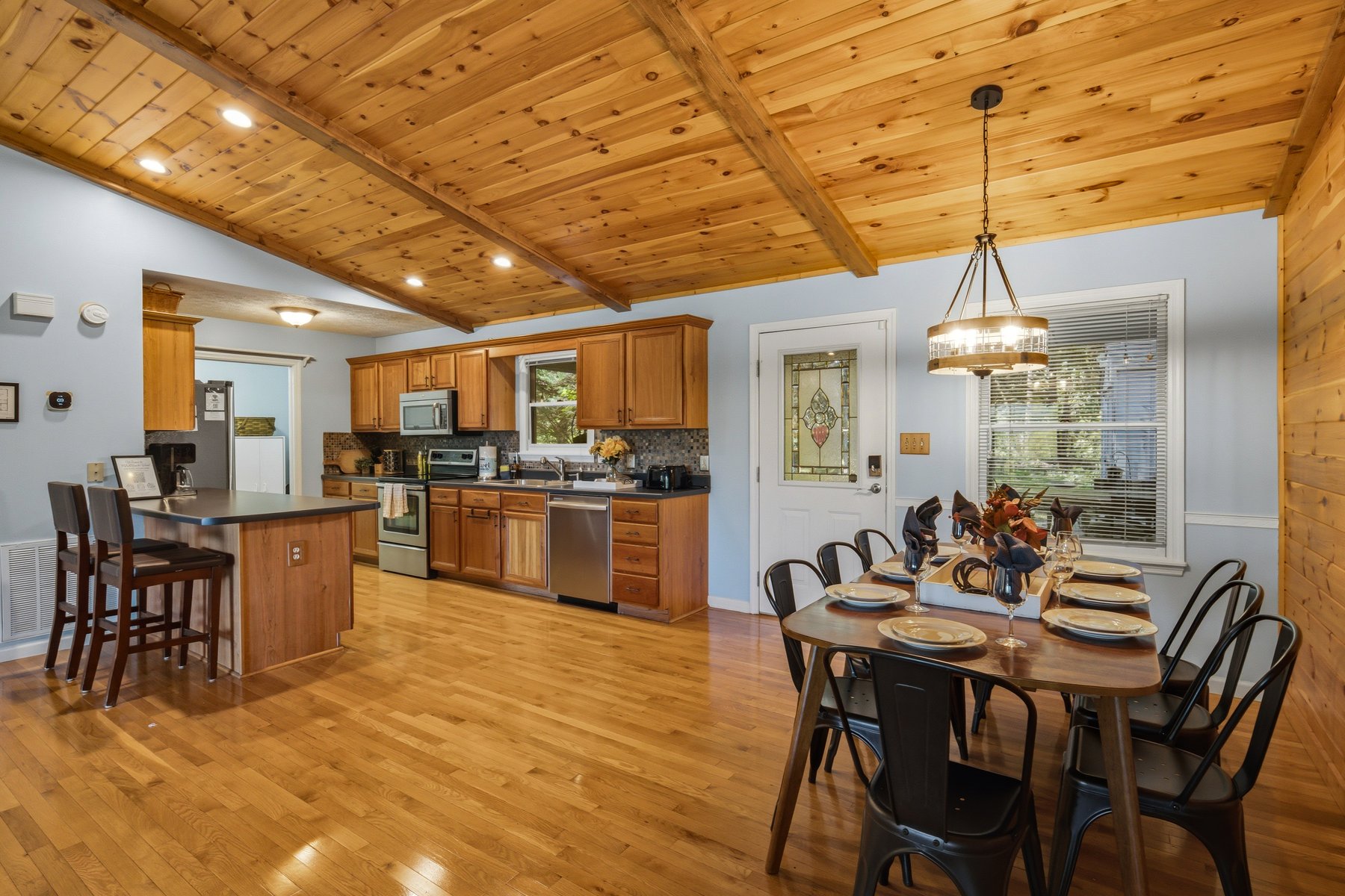 Kitchen and dining area with warm wood cabinetry and mountain light