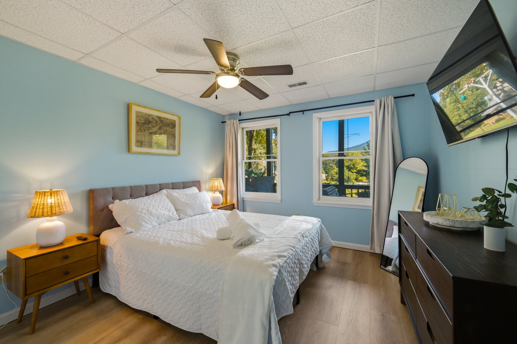 Bedroom with soft blue walls and windows toward the mountains