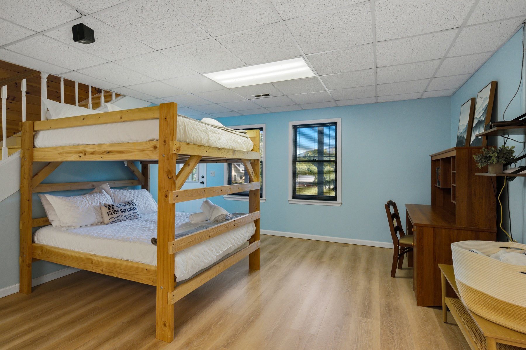 Bunk room with desk, mountain-facing window, and timber bunks
