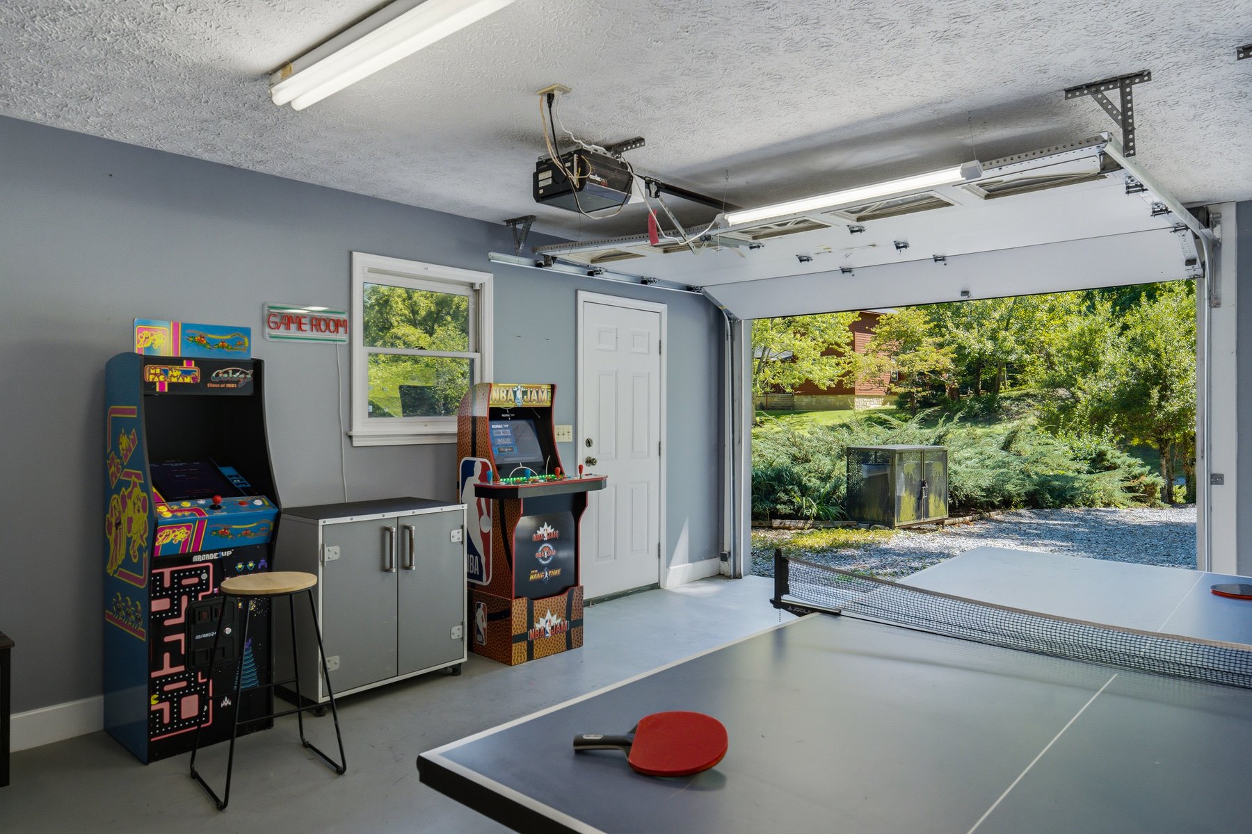 Garage game room with arcade cabinets and table tennis