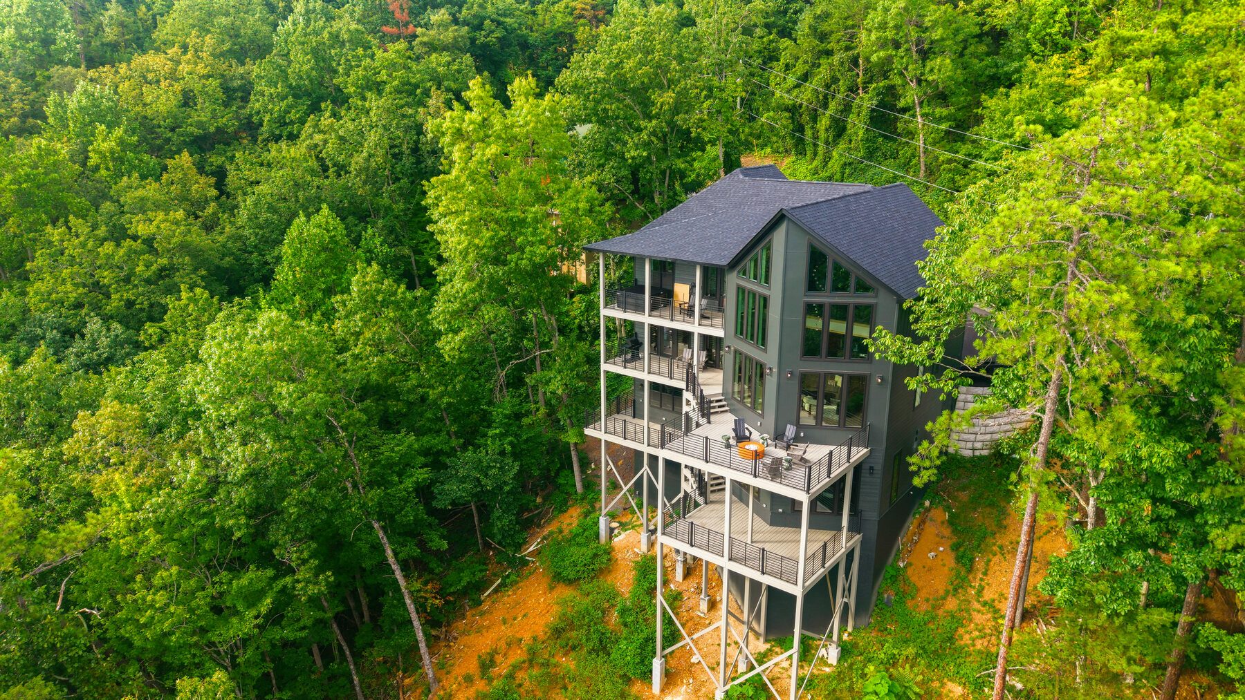 Aerial view of Milk & Honey rising from a wooded mountain slope