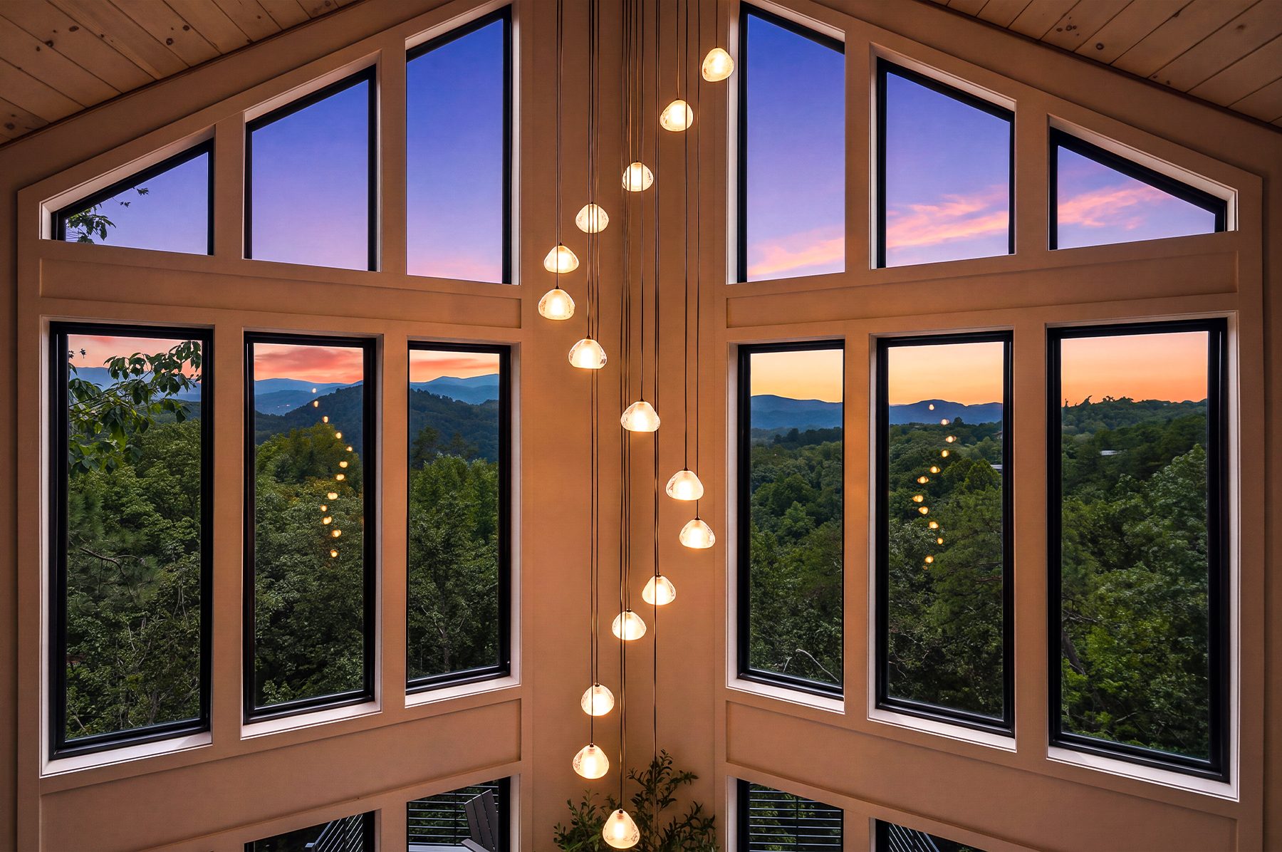 Two-story window wall framing the mountains from inside the cabin