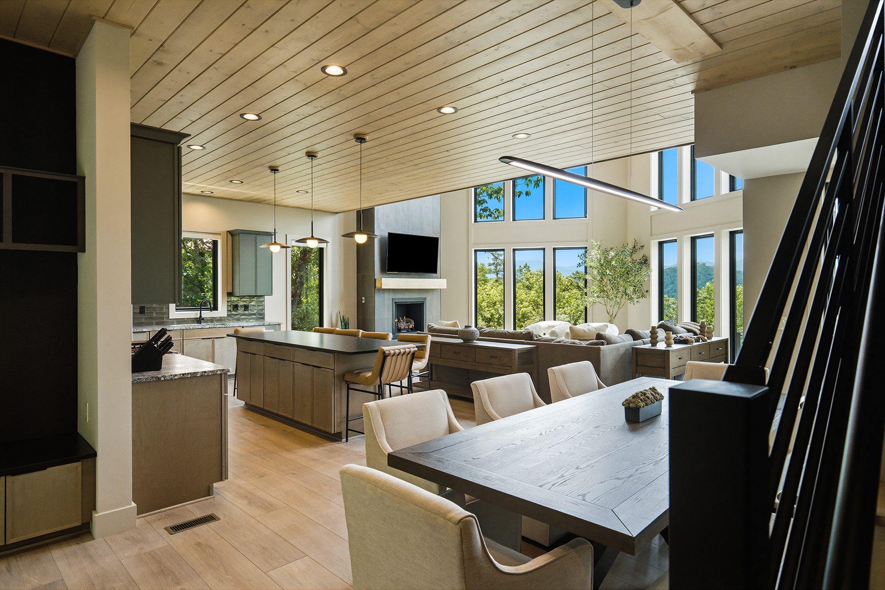 Open dining, kitchen, and living spaces beneath a timber ceiling