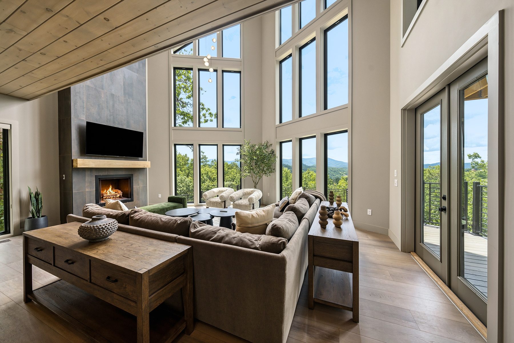 Living room arranged around the fireplace and mountain-facing windows