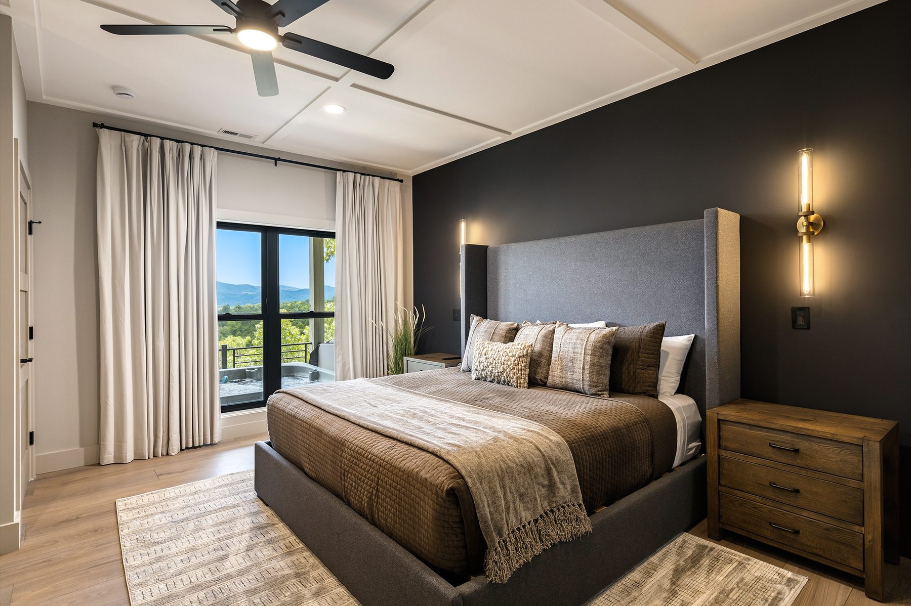 Dark, restful bedroom opening toward a mountain balcony
