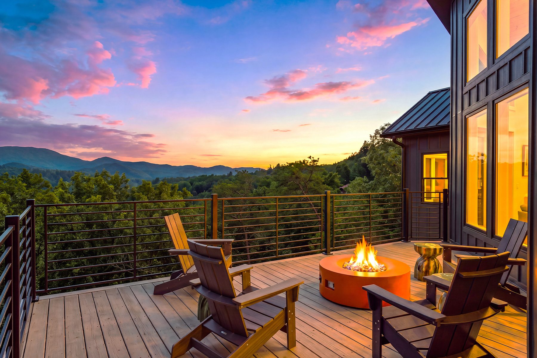 Fire pit and Adirondack chairs overlooking a vivid mountain sunset