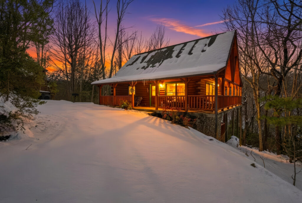 Smoky Mountain Cabin Twilight Exterior – Sevierville Tennessee Real Estate Photography log cabin in snow at sunset with glowing interior lights in Sevierville Tennessee Smoky Mountains